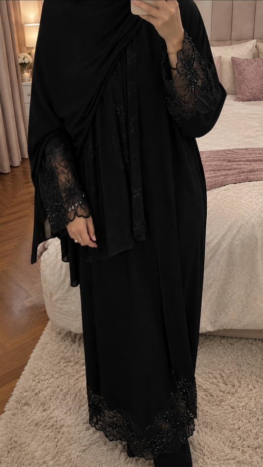 Femme portant une abaya noire Abayina en pied, silhouette longue et fluide