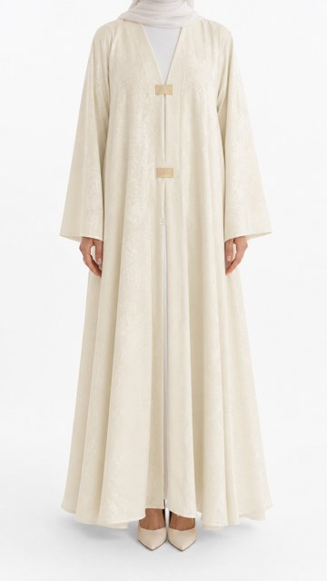 Abaya Yasmin ivoire vue de face, fermoirs dorés et tissu Nidah coréen texturé, coupe ample